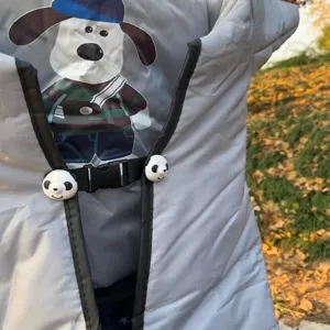 Vista detallada de la manta cortavientos para vehículos eléctricos con patrón de perro y clips de panda.