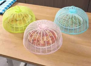 Vue détaillée de couvercles alimentaires en filet coloré sur table, protection anti-insectes.