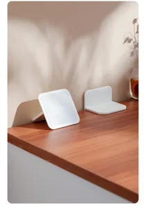 Details des weißen Kippschutzes für Möbel auf Holztisch, kindersichere Halterung.
