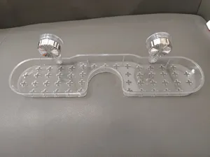Transparentes Dusch- und Wasserhahn-Ablageregal Detail mit Saugnäpfen und Abflusslöchern.