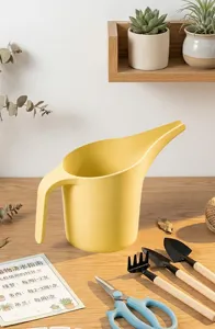 Detailopname van de kunststof gieter met lange tuit voor kamerplanten en tuinverzorging in huis.