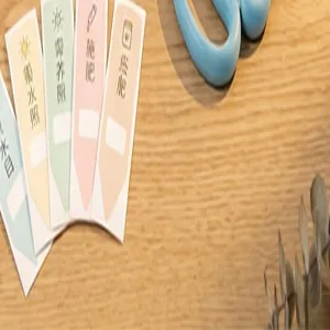 Tuinplantenlabels en gieter detailopname, ideal geschikt voor tuinverzorging en huishoudelijk gebruik.