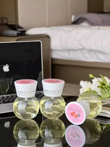 Detail view of inverted aroma diffuser balls with yellow essential oil and peach scent label.