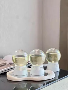 Detail view of inverted glass aroma diffuser balls with essential oil on white base and tray.