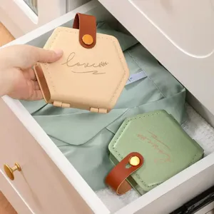 Caja de costura hexagonal portátil con asa de cuero y botón a presión para almacenamiento.