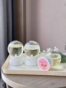 Detailed view of inverted aroma diffuser ball with peach fragrance in home setting display.