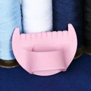 Detailed view of pink plastic sewing finger ring tool with molded number and cutting slot.