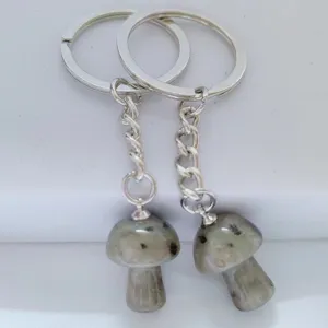 Natural crystal mushroom keychain pendant detail shot, polished stone charms for bags.