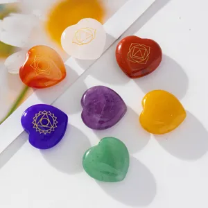 Pierres de cœur en cristal coloré naturel avec des symboles de chakra dorés pour le yoga.