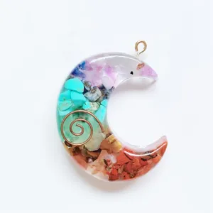 Crescent moon resin pendant detail showing colorful natural stone chips and copper spiral.