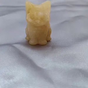 Close-up detail of a charming yellow crystal cat carving figurine, beautiful mineral gemstone craft.