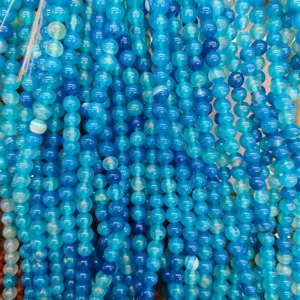 Detail shot of blue striped agate round beads for DIY jewelry making and handmade beading crafts.