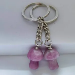 Detail shot of natural crystal pink mushroom keychain charm, cute stone key ring bag accessory.