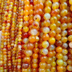 Close-up view of vibrant yellow and orange agate gemstone beads, perfect for DIY jewelry making.