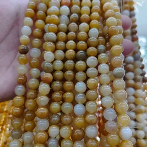 Primo piano di perline in pietra naturale con ricche variazioni di colore giallo e bianco.