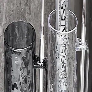 Detailed close-up of clear and grey striped mouthwash cups for home bathroom decor.