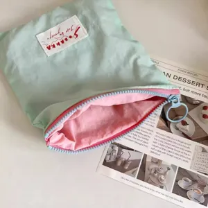 Portable macaron color blocking cosmetic bag with minimalist zipper and cute round pull ring detail.
