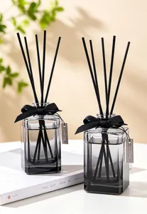 Black gradient glass reed diffuser bottle detail with black sticks and elegant bow decor.