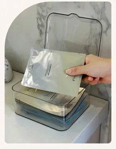 Clear acrylic makeup mask storage box detail view showing transparent flip lid and organized packs.