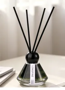 Close-up of glass reed diffuser bottle with black sticks, elegant home fragrance decor.