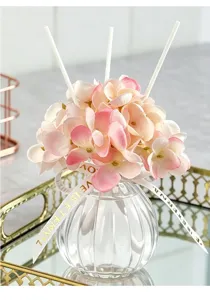 Difusor de aroma delicado con hortensias artificiales rosas en botella de vidrio para hogar.
