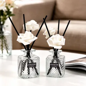 Set de difusor de aromaterapia con botellas de vidrio y varillas de flores blancas.