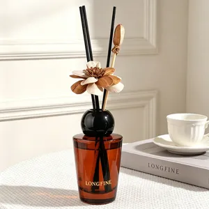 Amber glass reed diffuser set with elegant wooden flower sticks and black sphere cap for home decor.