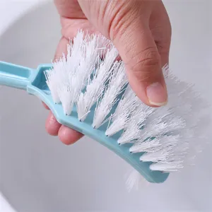 Brosse de toilette à long manche avec poils blancs flexibles et poignée en plastique.