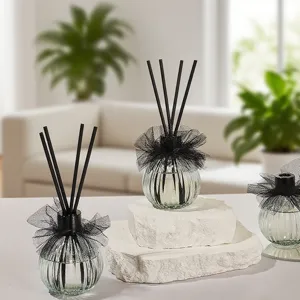 Elegante set de difusores de varillas con encaje negro sobre bases de piedra blanca