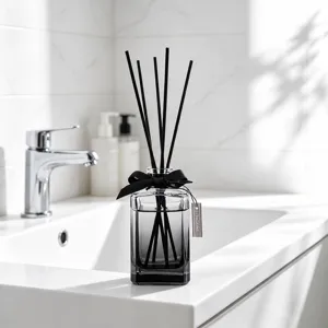 Aromatherapy diffuser bottle for home interior use with black reeds and bow decor.