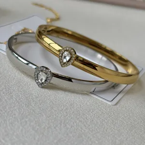 Primo piano dettagliato di bracciali minimalisti in oro e argento con cristalli a goccia