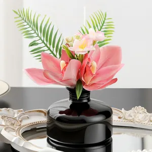 Elegant black bottle floral reed diffuser with pink orchids for home decor and aromatherapy.
