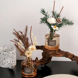 Ensemble de diffuseur de roseaux en verre marron automne avec fleurs sèches et bâtons en bois.