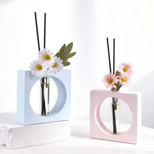Vase diffuseur d'arôme géométrique minimaliste avec fleurs artificielles et tiges de roseau.