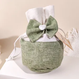 Detailed view of the cotton linen sachet bag with a cute green bow and heart bead.