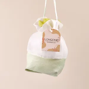 Detail view of a white and light green mesh sachet bag with hanging string and brand tag.