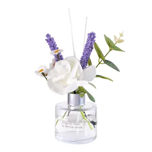 Diffuseur de roseaux en bouteille de verre avec fleurs artificielles pour décoration.