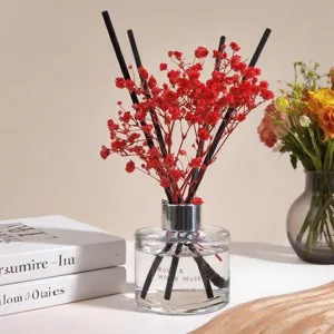 Difusor de aromas con flores secas rojas y varillas negras para decoración del hogar.
