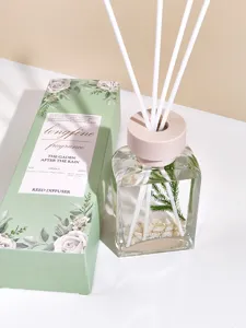 Detalle de difusor de aroma con botella de vidrio transparente y varillas blancas.