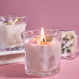 Gros plan détaillé d'une bougie parfumée en verre torsadé avec cristaux et fleurs séchées.