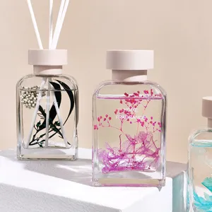 Primer plano detallado de un frasco difusor de vidrio con flores secas y aceite perfumado.