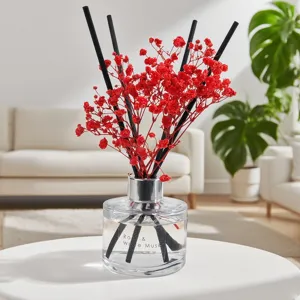 Elegante set de difusor de aromas con flores secas rojas y varillas negras para hogar.