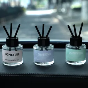 Car aromatherapy glass diffuser bottle set with black reed sticks for vehicle interior decor.