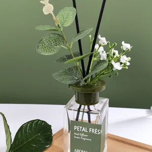 Glass bottle reed diffuser with green leaves and white flowers for home fragrance decoration
