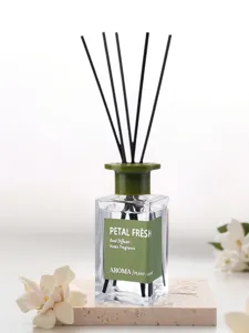 Home fragrance reed diffuser detail view with green label and black sticks for home decor.