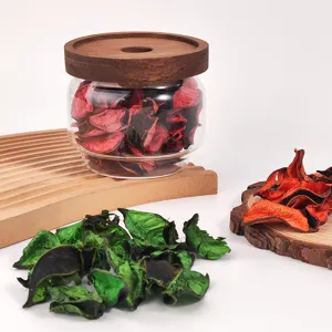 Decorative glass jar with wooden lid filled with colorful potpourri dried flowers for home decor.