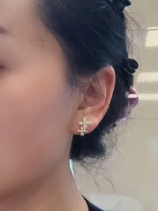 Detail shot of elegant gold-plated flower stud earrings with sparkling cubic zirconia stones