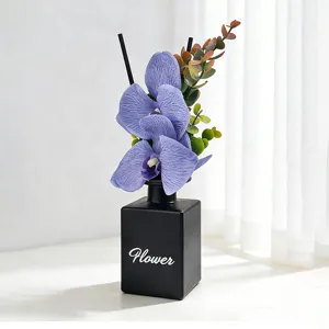 Diffuseur de parfum élégant en flacon noir avec orchidées mauves pour la maison.