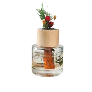 Glazen diffuserfles met houten dop, decoratieve gedroogde bloemen en geurolie voor thuisgebruik.