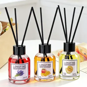 Set of 3 reed diffuser bottles with floral and fruit scents for home room air freshener decor.